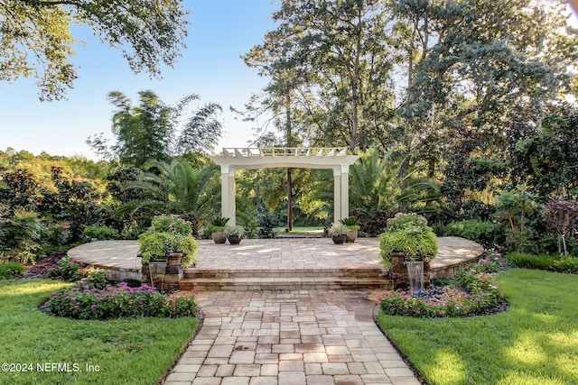 view of home's community with a pergola and a yard