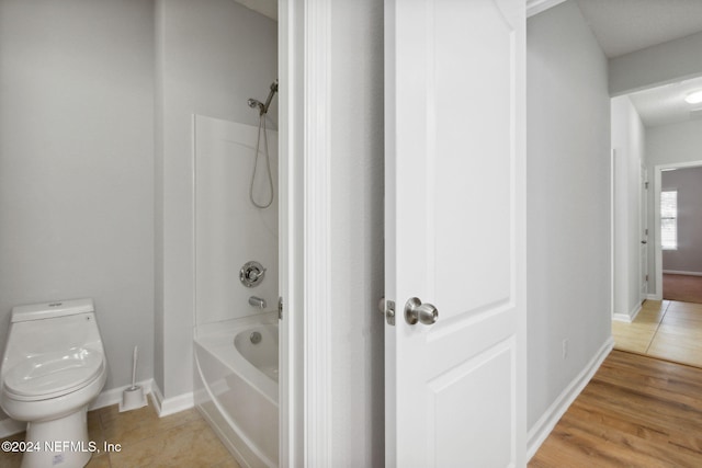 bathroom with shower / tub combination, toilet, and hardwood / wood-style flooring