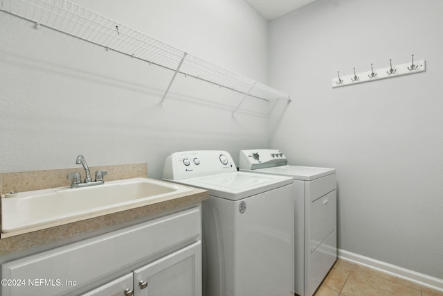 laundry area featuring cabinets, independent washer and dryer, light tile patterned flooring, and sink