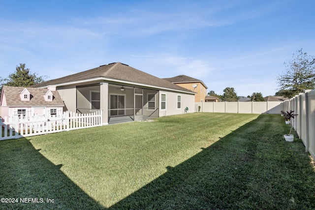 rear view of house with a sunroom and a lawn