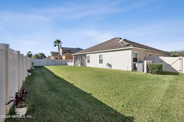 back of house with a yard and central AC