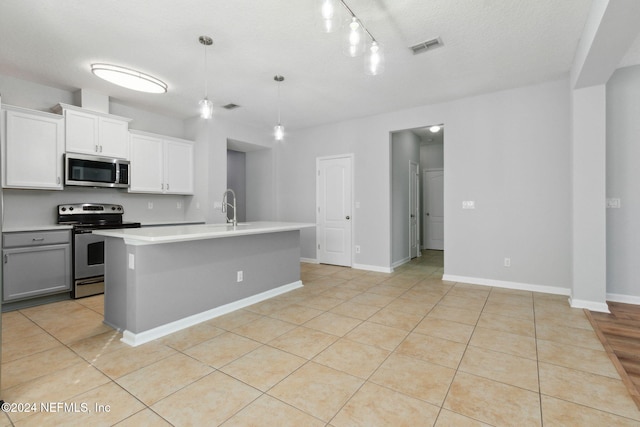 kitchen featuring pendant lighting, sink, an island with sink, appliances with stainless steel finishes, and white cabinetry