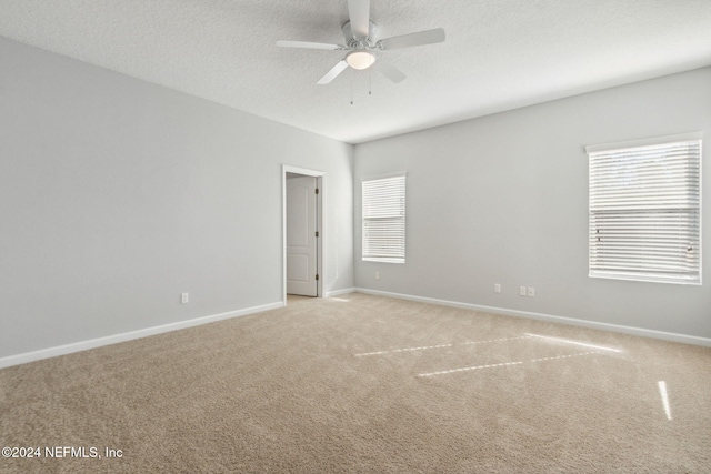 empty room with light carpet, a textured ceiling, and ceiling fan