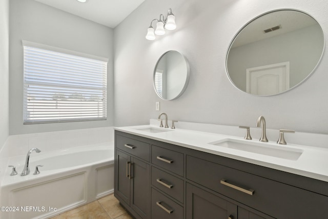 bathroom with tile patterned flooring, vanity, and a tub to relax in