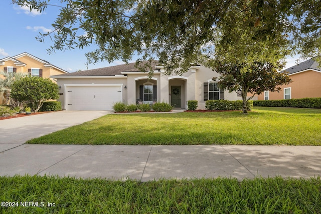 view of front of house featuring a garage and a front lawn