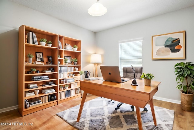 office with wood-type flooring and a textured ceiling