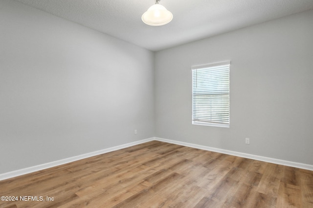 empty room featuring wood-type flooring and a textured ceiling