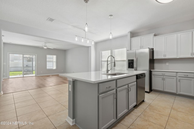 kitchen featuring dishwasher, a kitchen island with sink, sink, ceiling fan, and light tile patterned flooring