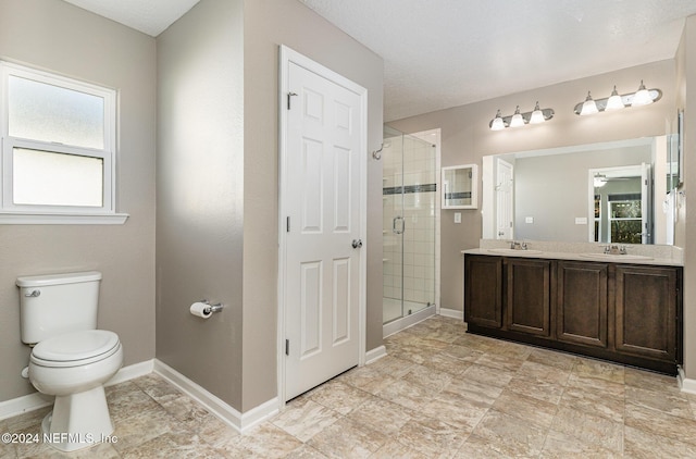 bathroom featuring a shower with door, vanity, a textured ceiling, and toilet