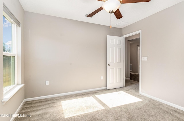 carpeted empty room featuring ceiling fan