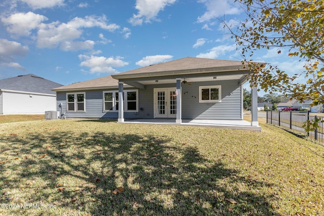 rear view of house with ceiling fan, a patio area, a yard, and central AC