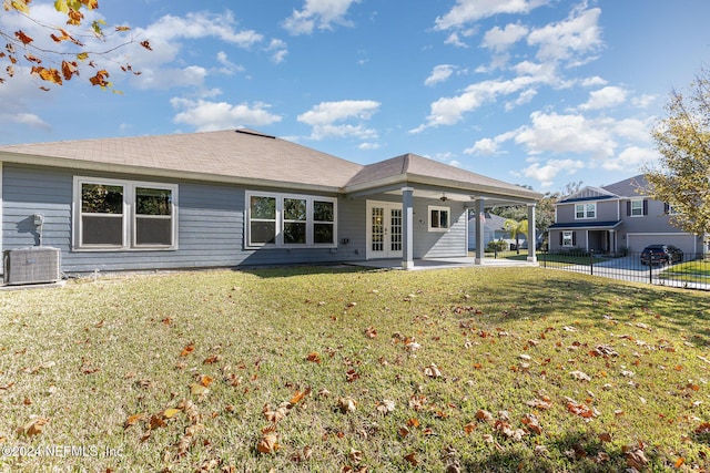 rear view of property featuring french doors, a patio, central air condition unit, and a yard