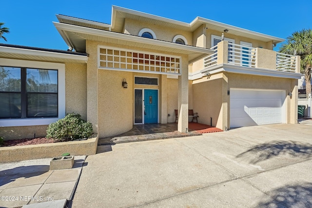 view of front of property featuring a balcony and a garage