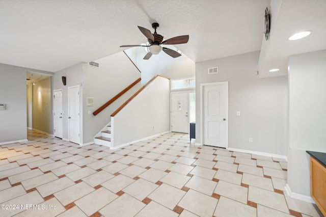 unfurnished living room with ceiling fan and vaulted ceiling