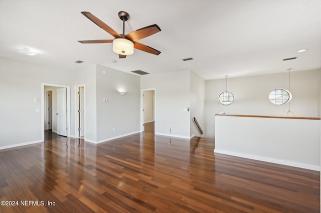 unfurnished living room with ceiling fan and dark wood-type flooring