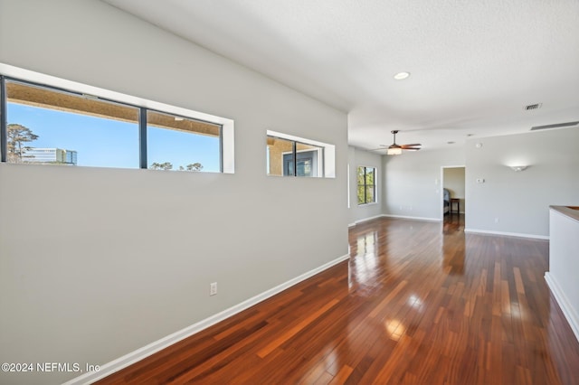 unfurnished room with ceiling fan and dark wood-type flooring