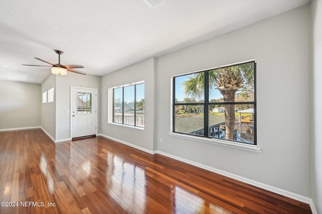 foyer entrance featuring a textured ceiling, dark hardwood / wood-style floors, and ceiling fan