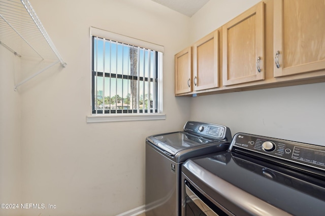 laundry area featuring washing machine and dryer and cabinets