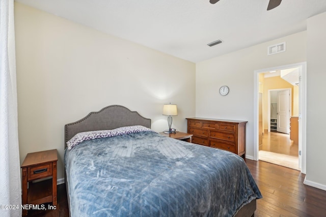 bedroom featuring connected bathroom, ceiling fan, and dark wood-type flooring