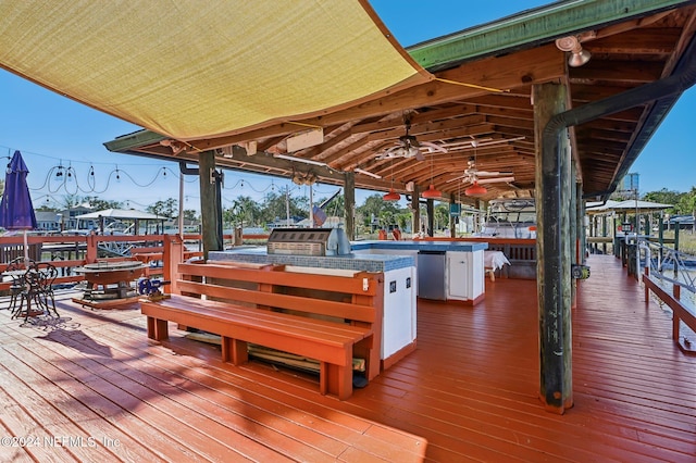 wooden deck featuring area for grilling, ceiling fan, and grilling area