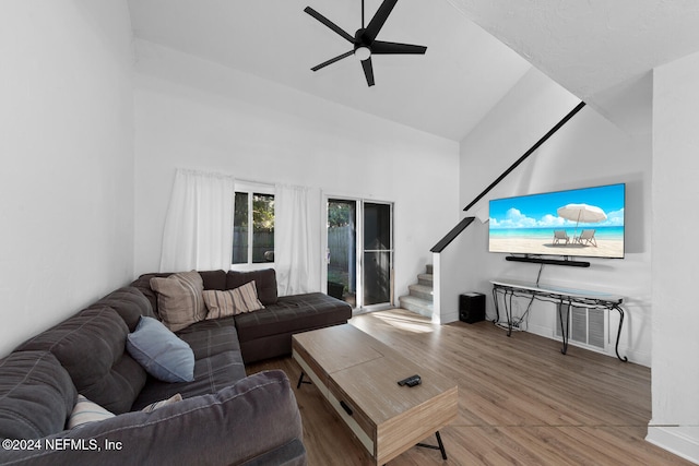 living room with ceiling fan, wood-type flooring, and high vaulted ceiling