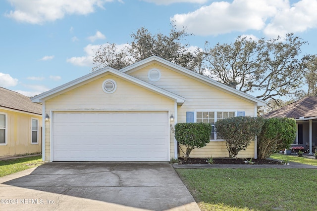 ranch-style home featuring a garage and a front lawn