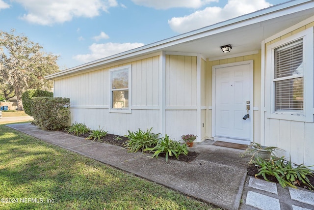 view of exterior entry with a lawn