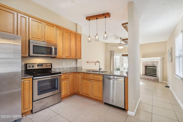 kitchen with pendant lighting, sink, ceiling fan, a textured ceiling, and appliances with stainless steel finishes