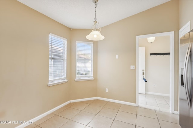 tiled spare room featuring a textured ceiling