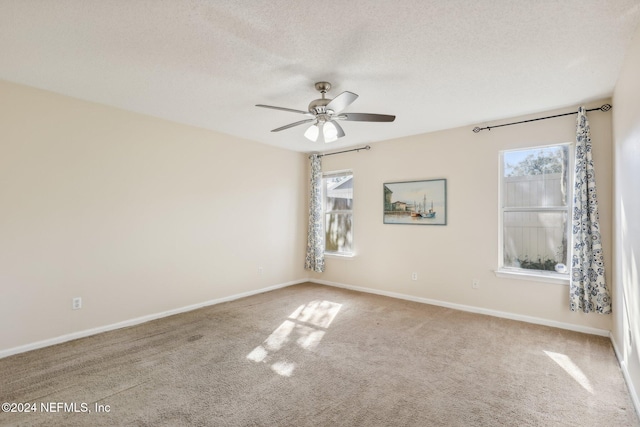 carpeted spare room featuring ceiling fan and a textured ceiling