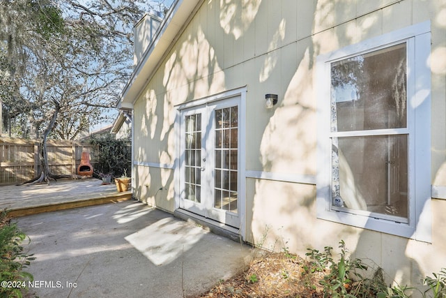 view of side of home featuring french doors, a patio, and a wooden deck