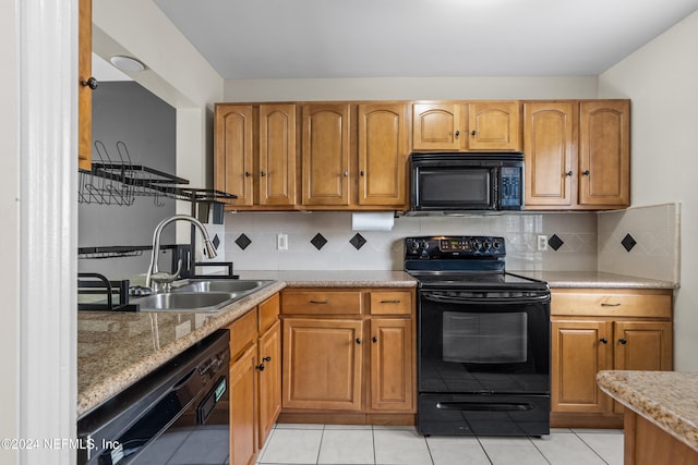 kitchen featuring decorative backsplash, sink, light tile patterned flooring, and black appliances