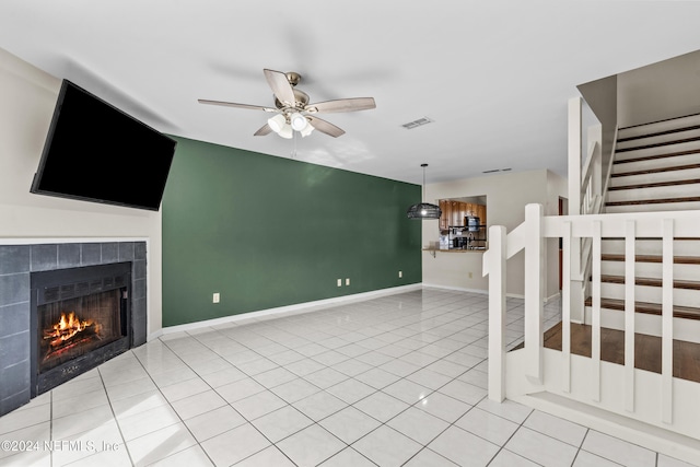 unfurnished living room with ceiling fan, light tile patterned floors, and a fireplace