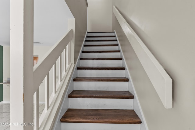 staircase featuring tile patterned flooring