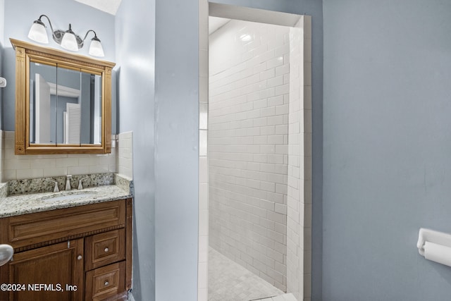 bathroom with vanity and tiled shower