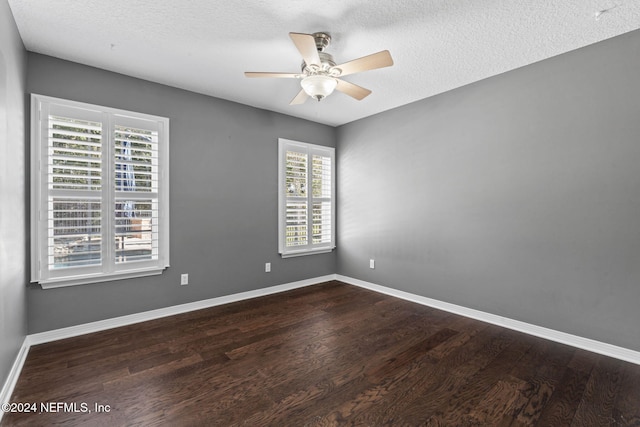 spare room with a textured ceiling, ceiling fan, and dark wood-type flooring