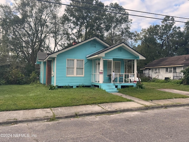 bungalow-style home featuring covered porch and a front yard