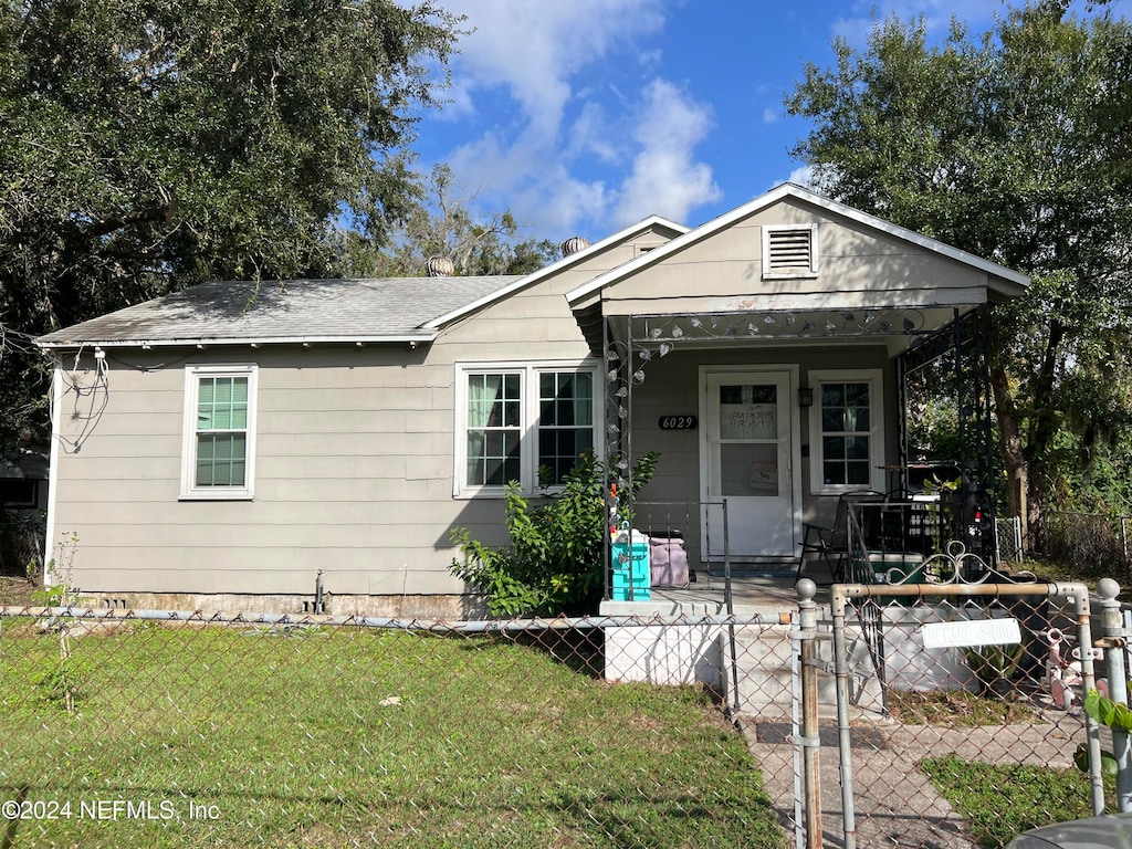 bungalow featuring covered porch and a front lawn