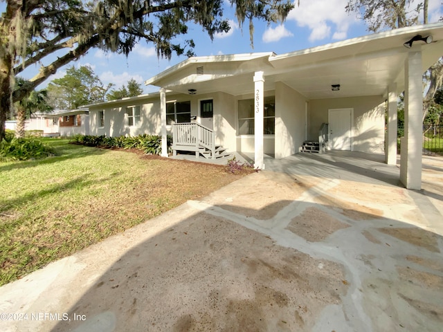 view of front of house featuring a carport and a front yard