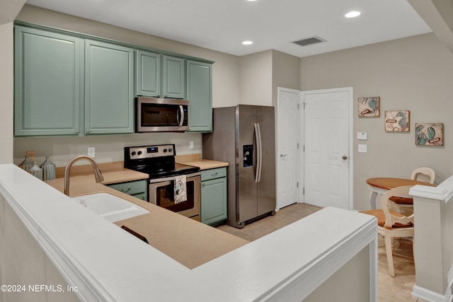 kitchen with sink, light tile patterned floors, and appliances with stainless steel finishes