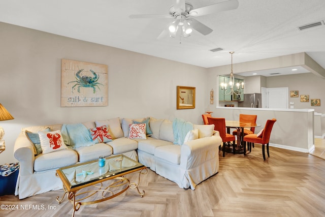 living room featuring light parquet floors and ceiling fan with notable chandelier