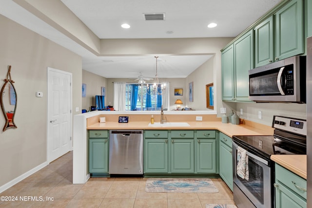 kitchen featuring kitchen peninsula, stainless steel appliances, green cabinets, and sink