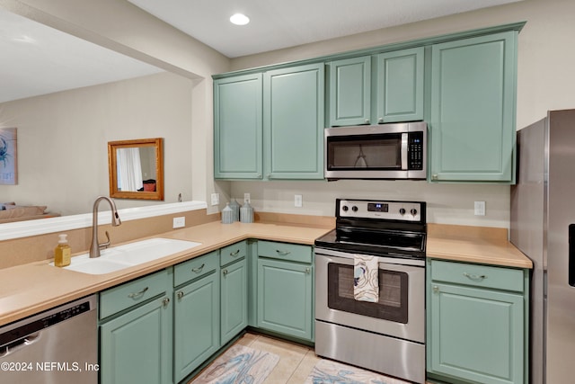 kitchen featuring green cabinets, sink, light tile patterned floors, and stainless steel appliances