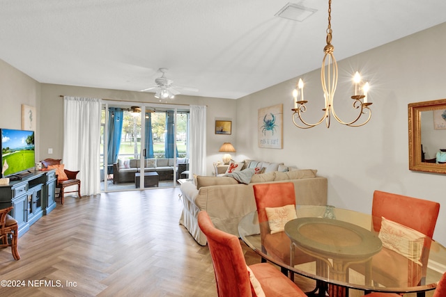 dining space featuring ceiling fan with notable chandelier and parquet flooring