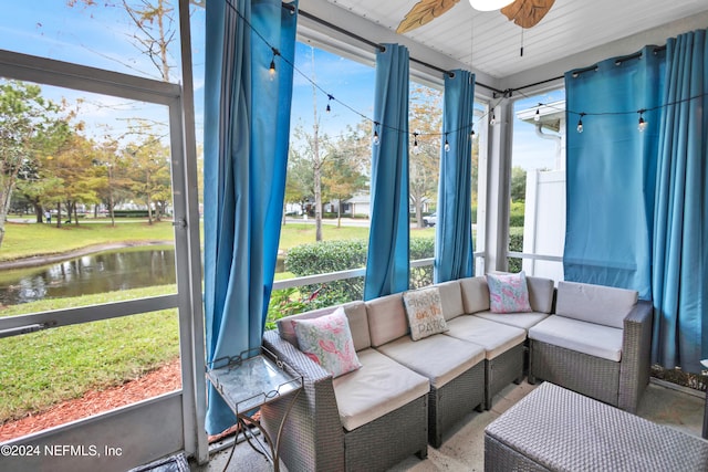 sunroom featuring ceiling fan, a water view, and a wealth of natural light