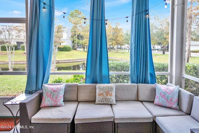 sunroom / solarium featuring a water view