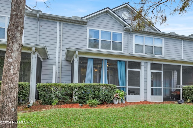 view of property with a sunroom and a front yard