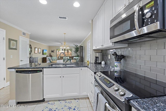 6100 A1A S Unit 419, Saint Augustine, FL 32080 - kitchen with stainless steel appliances, a sink, a peninsula, backsplash, and ornamental molding