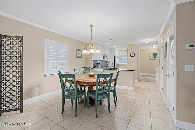 tiled dining area with a chandelier, a textured ceiling, and ornamental molding