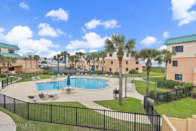 view of pool with a patio area and a lawn